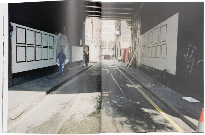 Open book showing two street scenes with pedestrians and urban elements.